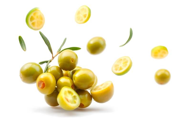 Green Olives Flying Against White Backdrop